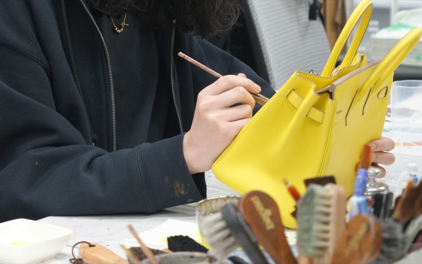 社内でバッグの色を補修している様子
